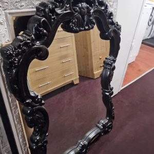 This large, ornate black wall mirror features intricate Baroque or Rococo style detailing. (072615)